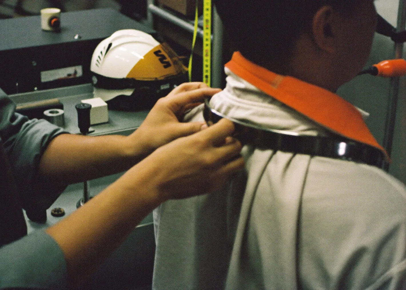 Technicians fitting a pressure suit neck ring